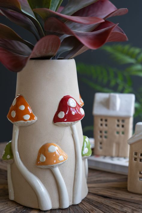 Display your blooms or botanicals in natural style. Toadstools in red, green, and yellow climb this 3D ceramic mushroom vase. Use it for kitchen utensils, year-round arrangements, or corner decor. Imported Brand: Kalalou Mushroom Vase, 3d Ceramic, Ceramic Mushroom, Coil Pottery, Corner Decor, Clay Vase, Mushroom Decor, Pottery Crafts, Diy Pottery