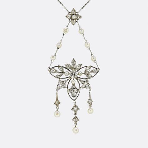 Here we have a delightful lavalier necklace dating back to the Edwardian era. An open platinum frame is centrally set with a round faceted old cut diamond which is surrounded by six fleur-de-lis motifs; each of which is set with matching diamonds and accompanied by freely falling natural pearls below. This focal pendant is suspended from a duo of pearl set chains which emanate from a diamond and pearl flower cluster above. This beautiful ensemble collectively hangs from a matching antique platin Lavalier Necklace, Flower Cluster, Antique Necklace, Necklace Box, Edwardian Era, Pearl Set, Pearl Flower, Fine Jewellery Necklace, Natural Pearls