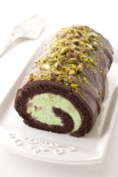 Chocolate and pistachio ice cream cake roll is covered with chocolate ganache and sprinkled with chopped pistachios. Pistachio Ice Cream Cake, Pistachio Roll Cake, Ice Cream Cake Roll, Arctic Roll, Cookie Monster Ice Cream, Hot Milk Cake, Chocolate Roll Cake, Almond Ice Cream, Swiss Rolls