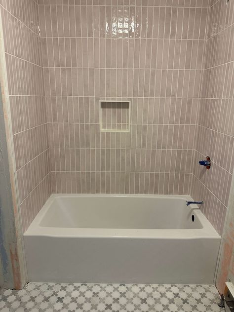 Vertical Tiles installed in the shower. The Tiles are blush and long. Vertical Subway Tile Bathtub, Paint Beadboard, Beadboard And Wallpaper, Tile Around Bathtub, Vertical Tile, Painted Beadboard, Hang Wallpaper, Vanity And Mirror, Bathroom Tub Shower