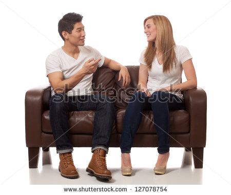 Young Couple on Sofa - stock photo Couple On Couch Drawing Reference, Couple Sitting On Couch Drawing, Two People Sitting On A Couch Drawing Reference, People Sitting On Couch Reference, Group Sitting On Couch Reference, Couples Sitting Poses Couch, Two People Sitting Together Reference, Interacting Poses, Couch Reference