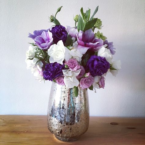 DIY purple, lilac, and white wedding centerpiece: anemones, carnations, and spray roses in a gold mercury vase.