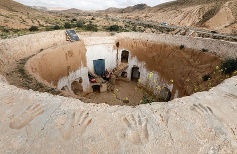 Saliha Mohamedi, 36, sits with her children in their troglodyte house on the outskirts of Matmata, Tunisia, on February 4, 2018. "I don't want to leave my house; it would be as if I was throwing my life and my traditions away," Saliha said. Case Sotterranee, Earth Bag Homes, Earth Sheltered, Unusual Buildings, Underground Homes, Cave House, Log Fires, Underground Cities, Desert Homes