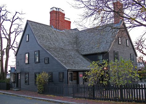 The House of Seven Gables has painted gray siding, shingle roofing, red brick chimneys, a gray picket fence, and dark gray trim. House Of Seven Gables, Salem Mass, Famous Houses, Salem Ma, Colonial House, The Seven, Old Houses, Black House, Places To See