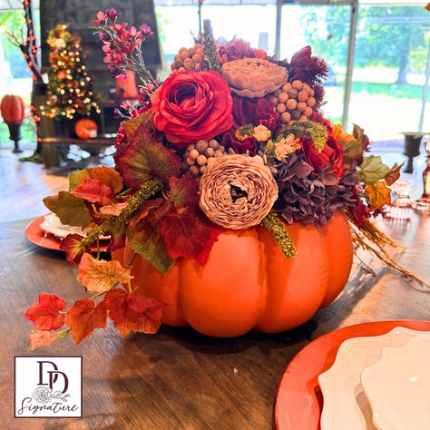 Experience the beauty of autumn with our Field Of Flowers Pumpkin Centerpiece. This stunning large pumpkin floral arrangement boasts beautiful hydrangeas and ranunculus, accented with autumn leaves. Add a touch of nature to your home décor and elevate any space with this unique centerpiece. Autumn Flower Display, Fall Table Centerpiece Ideas, Pumpkin Floral Centerpieces, Pumpkin Wedding Centerpieces, Pumpkin Flower Centerpiece, Pumpkin With Flowers, Pumpkin Table Centerpiece, Fall Dining Table Decor, Decorated Pumpkins