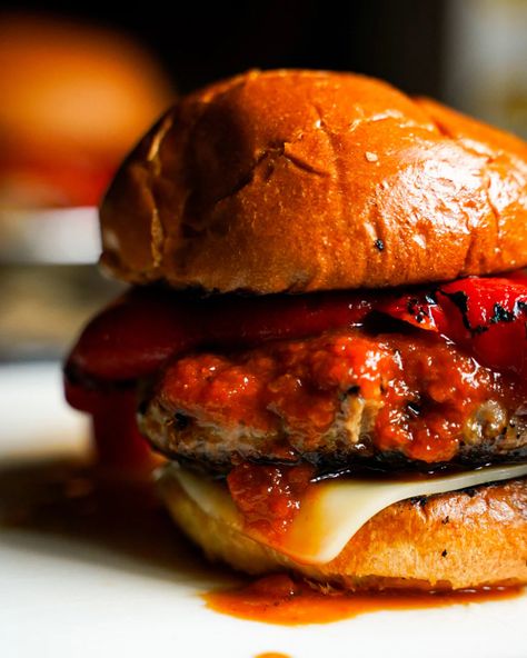 A close up of a burger with a toasted brioche bun and a ground beef and sweet Italian sausage patty that is on top of a slice of melted mozzarella cheese and covered in TJ's Marinara sauce, topped with a roasted red pepper Brioche Bun, Sausage Patty, Vegetarian Burger, Sweet Italian Sausage, Sandwich Cake, Food Contest, Beef Burger, Roasted Red Pepper, Brioche Buns