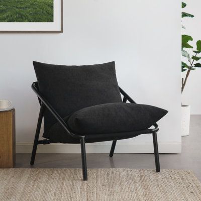 This armchair invites you to kick back and relax with its modern silhouette and foam cushioning. It features a pillow back and an open black metal base with four legs, providing a stylish yet cozy seating option. Upholstered in polyester fabric, it comes in five different colour options, including a soft cream boucle, to complement your home's modern aesthetic. The steel frame ensures the chair can handle daily use, while the removable cushion cover makes maintenance a breeze. This side chair is Office Breakout, Black Accent Chair, Accent Arm Chairs, Sling Chair, Chair Bed, Upholstered Arm Chair, Accent Chairs For Living Room, Furniture Outlet Stores, Foam Cushions