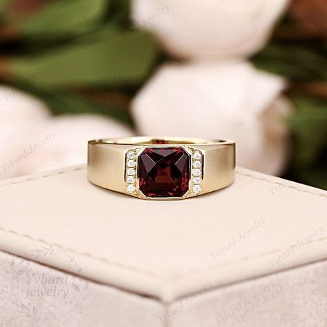 This ring is perfect for a man who appreciates classic and elegant jewelry. The deep red color of the garnet is eye-catching and the gold setting adds a touch of luxury. The side diamonds add a touch of sparkle and make the ring even more eye-catching. It would make a great gift for a special occasion, such as an engagement or wedding. Red 14k Gold Signet Ring For Wedding, Rings For Men Gold, Ring For Men Gold, Men Gold Ring, Gold Ring Men, Gold Garnet Ring, Ring With Ruby, Mens Gold Rings, Jewelry Details