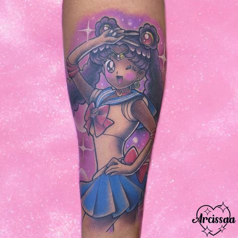 Black sailor moon tattoo. Her hair is black and has Afro puffs. She’s holding a victory pose and is standing in front of a pastel pink and lavender background. The tattoo is on a black woman. The tattoo is by @arcissaa at @harajukutattoo located in Jacksonville, FL. Anime Tattoos Dark Skin, Color Tattoo Black Skin, Kawaii Tattoo Black Skin, Tattoo Ideas Black Women Dark Skin, Cute Tattoos For Black Women, Harajuku Tattoo, Traditional Sailor Moon Tattoo, Sailor Moon Chest Tattoo, Sailor Moon Arm Tattoo