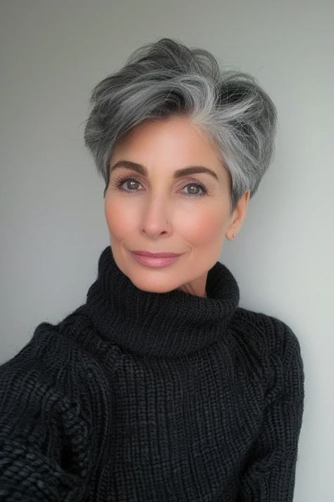 Elegant woman with short gray hair and a black turtleneck sweater smiling at the camera.