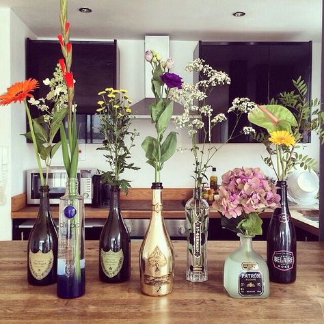 Flowers in alcohol bottles Alcohol Bottle Decorations, Bottle House, Wedding Bottles, Glass Bottles Decoration, Alcohol Bottles, The Fault In Our Stars, Bottle Vase, Champagne Bottle, Plant Decor