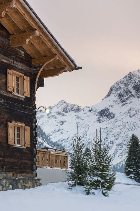 Side of a chalet with wood panelling nd eaves with snowy foreground and snow-covered mountain with pale sunset in background. Luxury Chalet, Austrian Alps, Luxury Ski Chalet, Ski Chalets, Luxury Ski, Ski Chalet, Luxury Services, Indoor Swimming Pools, Mountain Views