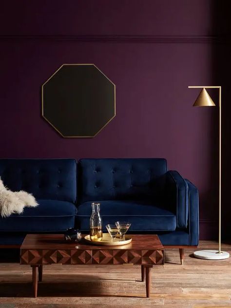 an exquisite living room with a deep purple accent wall, a navy sofa, a beautiful wooden coffee table and a gold floor lamp Purple Accent Wall, Purple Accent Walls, Purple Living Room, Purple Bedroom, Interior Design Per La Casa, Room Paint Colors, Purple Walls, Paint Colors For Living Room, Living Room Paint