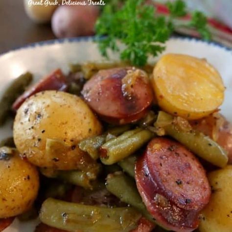 Preheat oven to 400° and spray a 9x13 baking dish with a non stick spray. Wash creamer potatoes, cut in half and add to a sealable gallon size baggie. Add oil, seasonings, pepper and red pepper flakes to baggie. Shake to coat. In a large frying pan, add sausage and water and cook over medium high heat until sausages have browned and most of water has evaporated. Remove sausage from pan and when cool enough add to baggie. Melt butter in frying pan and add onions and garlic, cook until onions ... Foil Meals, Bbq Foods, Potatoes Green Beans, Oven Meals, Green Beans Side Dish, Potatoes And Green Beans, Smoked Sausage Recipes, Fish Fingers, Foil Dinners