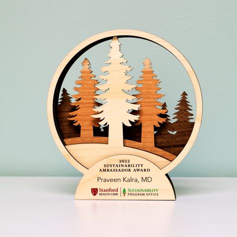 Check out this cool forest award we created from wooden layers cut out with our solar powered laser engraver! #forest #sustainabilityaward #treetrophy #lasercut #ecofriendly #green #solarpower #design #handmade #gift Wooden Trophy Design Ideas, Wood Trophy Design, Forest Laser Cut, Star Trophy Design, Wooden Award Trophy Design, Wooden Award, Bike Art Print, Trophy Plaques, Award Ideas