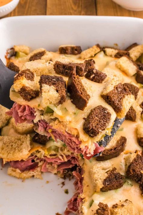 Reuben Casserole is a tasty dish loaded with cubes of rye bread, sliced corned beef, sauerkraut, dill pickles, Swiss cheese and Thousand Island dressing. Reuben Squares, Rueban Casserole Corned Beef, Hearty Reuben Bake Casserole, Oven Baked Reuben Casserole, Ruben Casserole, Ruben Bake Reuben Casserole, Reuben Bake With Rye Bread, Rubin Casserole Recipes For Corned Beef, Reuben Recipes