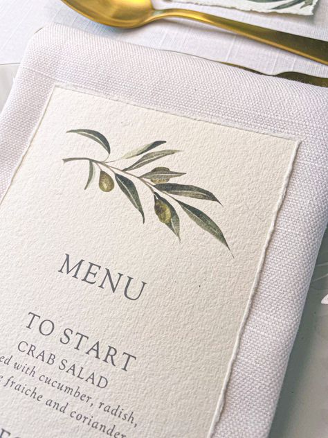 OLIVE MENU MINIMUM ORDER OF 10 This exquisite wedding menu features a beautiful watercolour olive branch printed onto luxurious handmade recycled 320gsm cotton paper with a delicate hand torn deckled edge. Handmade in my Devon studio by the sea. Size 10 x 19cm || TO ORDER || Please detail your wedding menu in the personalisation box when ordering and add the quantity you need when the item is in your basket.  Please check the wording of your menu carefully as your exact phrases and words will be used. || PLEASE NOTE || Please note that due to the handmade nature of the recycled cotton paper, slight variances in colour may occur and speckles may be present in the paper. || MATCHING PRODUCTS || This design is also available as place cards, calligraphy place cards, personalised table numbers Olive Branch Wedding Decor, Watercolor Menu Design, Olive Theme Wedding, Olive Wedding Invitations, Branches Wedding Decor, 2026 Wedding, Olive Branch Wedding, Watercolor Menu, Wedding Menus Design