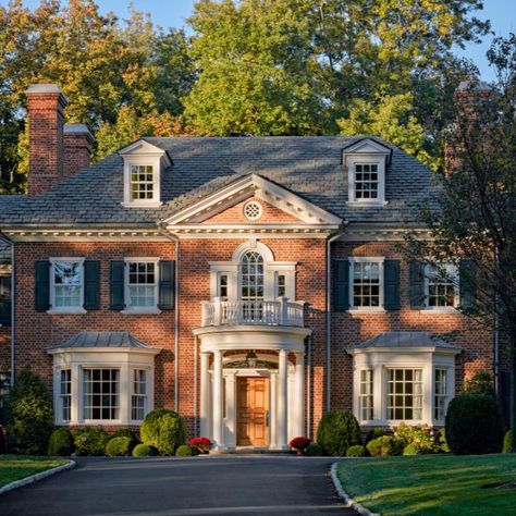 This new 7,000 square foot brick home was built for a growing young family as a long-term family homestead. The Georgian revival style was chosen to help the house fit seamlessly into the neighborhood, a region already marked by its early 20th century Georgian and Tudor Revival homes. #redbrickhouse #slateroof #modillions #dormers #palladianwindow #doriccolumns #windowbay #frontportico #curvedporch #georgianstyle #traditionalarchitecture #classicaldesign #khakumwood #GreenwichCT Georgian Revival Homes, Georgian Style Homes, Dream Things, Georgian Architecture, Brick Exterior House, Georgian Homes, Dream House Exterior, Colonial House, House Goals