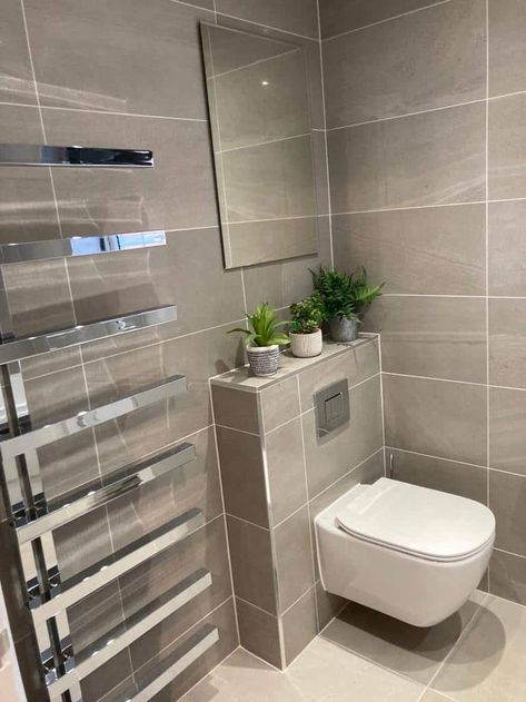 Bathroom with grey wall tiles and cream floor tiles. There is a modern radiator to the left of the toilet. Above the toilet there is a mirror on the wall and three potted plants on a shelf. 30 X 60 Tiles Bathroom, Matte Floor Tiles, Stone Effect Wall, Bathroom Layout Plans, 30x40 House Plans, Modern Bathroom Renovations, Tiles Uk, Bathroom Transformation, Washroom Design