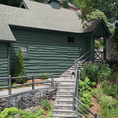 Cabin painted in deep green with gray railing and stone staircase. Cabin Exterior Paint Colors, Green Exterior Cabin Colors, Lake House Green Exterior, Green Front Door Log Cabin, Dark Green Cabin Exterior Paint, Dark Green Log Cabin, Cabin Paint Colors, Small Beach Cottage, Exterior Stain Colors