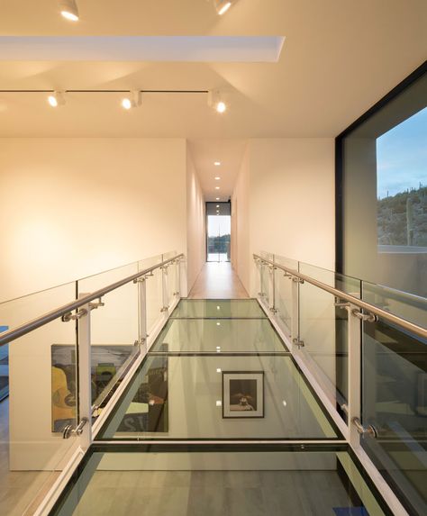 In this modern house, there's a glass bridge that crosses the art gallery and connects the living areas with the bedrooms. #GlassBridge #Architecture #GlassWalkway Glass Floors Architecture, Modern Hillside House, House In Arizona, Glass Walkway, Modernist Furniture, Glass Bridge, Hillside House, Desert Homes, Interior Stairs