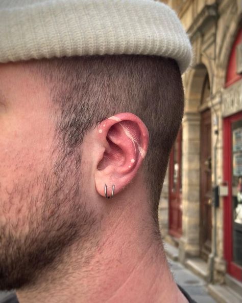 White inked ear tattoo design Ear Tattoo Inner Men, Healed Ear Tattoo, White Tattoo Ear, White Ink Ear Tattoo, Men’s Ear Tattoo, White Ear Tattoo, Wing Ear Tattoo, Tattoos By Ear, Tattooed Ear