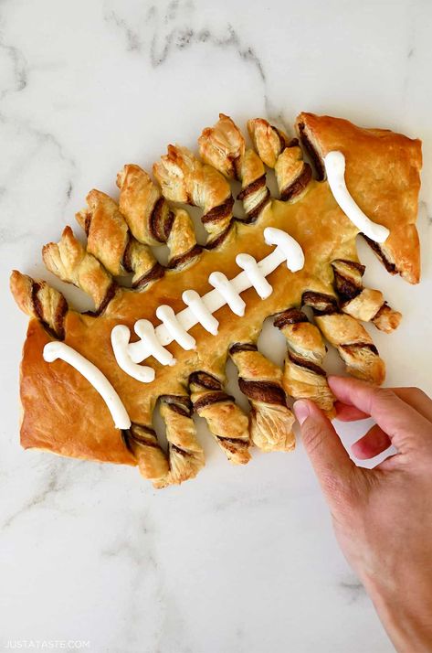 Get ready to elevate your game day spread with a show-stopping treat that's as delicious as it is Instagram-worthy – the Puff Pastry Football! All you need is four simple ingredients for this buttery puff pastry dessert filled with creamy Nutella. Football Desserts, Puff Pastry Dessert, Football Food Appetizers, Football Tailgate Food, Nutella Puff Pastry, Puff Pastry Twists, Pastries Recipes Dessert, Football Party Foods, Puff Pastry Appetizers