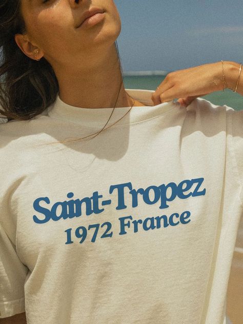 Capture the glamour and sophistication of Saint Tropez with our vintage-inspired T-Shirt! 🌟🌴 Featuring a retro graphic design, this tee brings the essence of the iconic French Riviera destination to your wardrobe. Made from soft, breathable fabric, it's perfect for any occasion, offering both comfort and style. Whether you're reminiscing about a trip or dreaming of one, this shirt is a chic addition to your collection. Details: Material: 100% Cotton Sizes: S, M, L, XL, XXL Care: Machine wash c Luxury Classic Summer T-shirt, French Riviera Aesthetic, Swim Team Shirts, Beautiful Coastline, East Coast Fashion, French Riviera Style, Riviera Style, Vintage Shirt Design, Retro Graphic Design