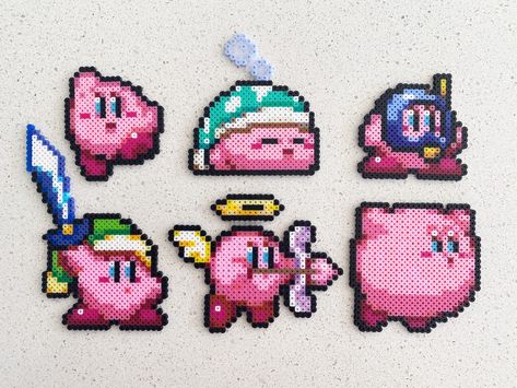 Kirby- Pixel Perler Beads Art, Can be Fridge Magnet, Keychain, Phone Charm, and Badge! --Size-- Kirby 1: 2 1/4 inches tall by 2 inches wide. Kirby 2: 3 inches tall by 2 3/4 inches wide. Kirby 3: 2 inches tall by 2 1/8 inches wide. Kirby 4: 4 inches tall by 3 inches wide. Kirby 5: 3 inches tall by 3 1/2 inches wide. Kirby 6: 2 1/2 inches tall by 2 1/2 inches wide. --Multiple finishes--  Plain: just keep it simple Magnet: a black magnet Keychain: a simple iron ring Phone charm: a black mobile phon Kirby Perler Bead Patterns Small, Small Kirby Perler Beads, Kirby Fuse Beads, Lava Lamp Pixel Art, Peeler Bead Magnets, Small Pokemon Pixel Art, Kirby Pearl Beads, Iron Beads Keychain, Kirby Pixel Art Grid