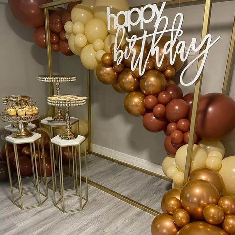 Create an opulent birthday backdrop setup with dazzling decor elements. Set up a gold metal backdrop stand and bedeck it with charming champagne, caramel & gold balloons to exude grandeur. Place gold geometric column stands along with white Plexiglass sheets and display gold pearl embellished cake stands on them to add a spectacular flair to your birthday party décor. Metal Backdrop Stand, Backdrop Setup, Metal Backdrop, Event Decor Ideas, Party Decorations Table, Plexiglass Sheets, Gorgeous Birthday, Birthday Roses, Balloon Stands