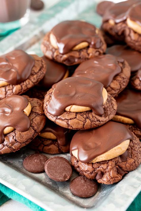 Buckeye Cookies have a boxed brownie cookie base that's covered in a peanut butter topping before being finished off with melted chocolate! Whip up over two dozen cookies in under 30 minutes! Recipe For Buckeyes, Buckeyes Cookies, Buckeye Cookies Recipe, Buckeye Brownie Cookies, Buckeye Cookies, Buckeye Brownies, Cookie Base, Chocolate Brownie Cookies, Cookie Brownie Recipe