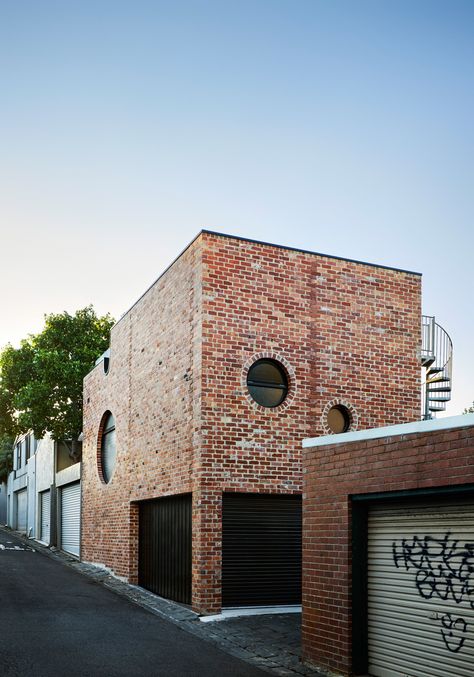 Small red- and blue-glazed bricks pattern the walls of this house by Austin Maynard Architects, which replaces a garage in the Melbourne suburb of Richmond. Modern Brick House, Round Windows, Melbourne Suburbs, Garage Renovation, Recycled Brick, Glazed Brick, Backyard Buildings, Modern Architecture Design, Modern Garage