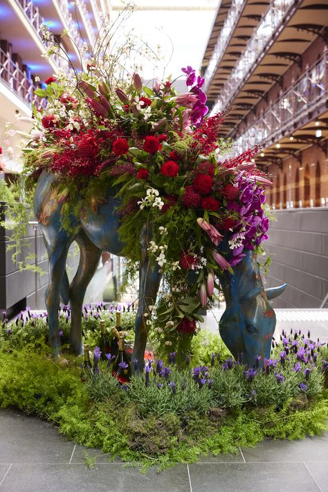 Inside a large hotel lobby, a turquoise horse sculpture with an abundance of spring blooms including dogwood, roses, waratah, oriental lilies, lavender, and cascading phalaenopsis orchids and jasmine tendrils styled on it's saddle, bows it's head into a bed of lavender and moss. Carnival Flowers, Melbourne Photography, Activation Ideas, Spring Racing Carnival, Horse Flowers, Corporate Flowers, Business Lunch, Horse Things, Spring Racing