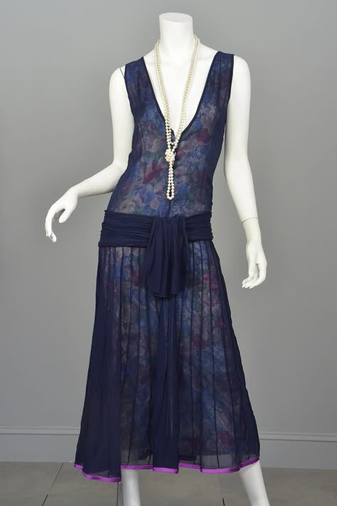 The neckline, with working covered buttons, can plunge as low as you want it to.  The drop waist, accentuated with a gathered band and peplum-like sash, is very sassy.  The skirt is micro pleated, falling in a gentle a line to a purple satin ribbon embellished hemline.  And...it is completely lined in a soft floral fabric which is detectable through the sheer navy blue outer-layer. Drop Waist Dress Outfit, 20’s Fashion, Flared Mini Dress, 1920s Women, 1920 Fashion, 1920s Flapper Dress, Drop Waist Dress, 20s Fashion, 1920s Flapper