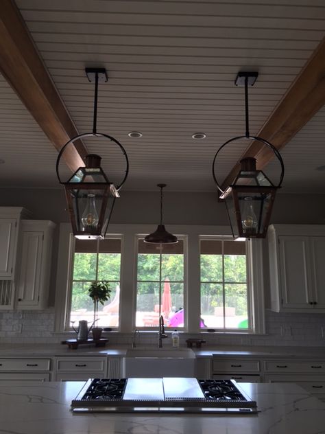 Triple threat in the kitchen! #Bevolo's Farmhouse pendant hangs prominently over the farmhouse sink and two French Quarter Lanterns on Yokes illuminate the kitchen island workspace. Pendant Island Lighting, Lake Kitchen, Kitchens Cabinets, Beach Kitchen, Hanging Lighting, Beach Kitchens, Industrial Farmhouse, Farmhouse Sink, Triple Threat