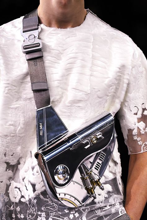 Dior’s Sorayama Metal Saddle bag at the techno-futuristic Dior Homme pre-fall 2019 show held in Tokyo features Artist Hajime Sorayama Dior Futuristic, Luxury Functional Streetwear Bags, Dior Saddle Bag Men, Dior Men Bag, Dior Crossbody Bag Men, Streetwear Bag With Functional Pockets, Prada Shoulder Bag Men, Black Techwear Shoulder Bag, Hajime Sorayama