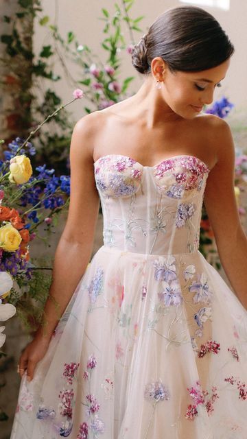 💐Floral Wedding Gowns💐  Which of these Hand-painted gowns is your favorite? A colorful wedding dress is the perfect focal point for a modern bride looking for some color for her wedding. Beautiful feminine shades of pink and purple! Wedding Dress With Colourful Flowers, Wedding Dress With Flowers On Skirt, Wedding Dress With Coloured Flowers, Wedding Dress With Colorful Accents, Reception Dress Floral, Floral Colorful Wedding Dress, Unique Wedding Dresses Floral, Pastel Floral Wedding Dress, Bright Floral Wedding Dress