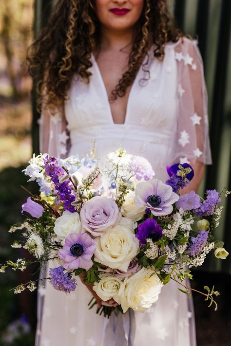 A naturally styled wedding bouquet designed to compliment the beauty of a bluebell wood in full bloom. In various shades of purple and using seasonal spring flowers including anemones, hellebores, and spirea with roses, scabious and delphiniums. Designed and created by Bryony Mae Flowers for a photoshoot at @thegreenescape in the Surrey Hills. Photography by www.kirstymackenziephotography.co.uk Anenome Bouquets, Wood Wedding Ideas, Wedding Inspiration Purple, Bluebell Woodland, Purple Bride Bouquet, Florist Ideas, Woodland Wedding Venues, Woodland Wedding Inspiration, Enchanted Woodland