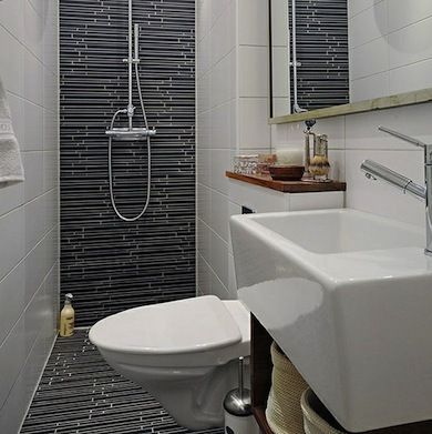 Transitional Tile    This bathroom is mostly unadorned, apart from one striking design element—the tile. The black linear tile ascends from the floor up the back wall of the shower, creating a streamlined, modern look Design Interior Baie, Klein Toilet, Small Shower Room, Ideas Baños, Bilik Air, Narrow Bathroom, Small Showers, Decor Baie, Tiny Bathrooms