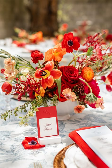 red floral centerpiece on classic tablescape • "Surprise Red" Twist on a Classic Blue and White Wedding Editorial at Colvin House • Savoir Fête, Chicago Wedding Planner • Photography by Alex Ferreri Blue Red And Orange Wedding, Red And Orange Party Decor, Red Orange Bridal Bouquet, Red And Orange Floral Arrangements, Orange Red Wedding Theme, Red And Orange Wedding Decorations, Orange Spring Flowers, Bold Wedding Florals, Red Flower Wedding Decoration