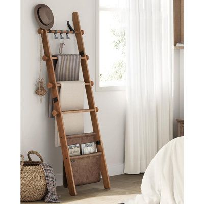 Transform your living space with this blanket ladder. This 5-tier ladder shelf features 4 hanging rods perfect for displaying towels, blankets, or sheets, and a bottom synthetic leather bag for clothes, decor, or other items. Keep your living room or bedroom clean and organized while adding a stylish touch to your home decor. | One Allium Way 5-Tier Decorative Farmhouse Blanket Rack w/ Synthetic Leather Bag, Metal Hooks, Side Hooks Brown | C111811278_403191563 | Wayfair Canada Farmhouse Blanket, Wood Blanket Ladder, Wooden Blanket Ladder, Wooden Ladder Shelf, Bag For Clothes, Display Towels, Farmhouse Blankets, Blanket Rack, Quilt Rack