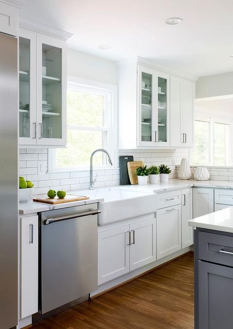 A stainless steel dishwasher displayed next to a farmhouse kitchen sink surrounding white shaker cabinets, a kitchen window, and white subway tiles. Kitchen Window Design, Stainless Steel Farmhouse Sink, Sinks Kitchen Stainless, White Shaker Cabinets, Sink Kitchen, Kitchen Pantry Cabinets, Small Space Kitchen, Shaker Cabinets, Sink Design