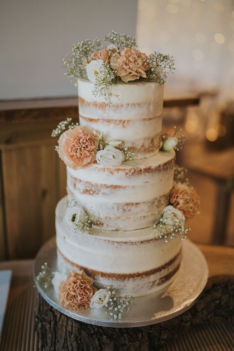 Three tier naked wedding cake with white frosting and floral decor Scrapped Wedding Cake, Barely Iced Wedding Cake, Bare Icing Wedding Cake, Wedding Cake No Icing, Semi Naked Cake Wedding, Three Tiered Wedding Cake, Crumb Coat Wedding Cake, Chantilly Wedding Cake, 3 Tier Naked Wedding Cake