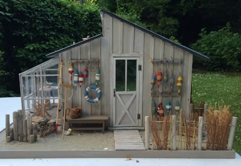 Fishing shack? I like the buoys. Fishing Shed, Miniature Beach House, Fishing Cottage, Cabin Dollhouse, Fish Shack, Fishing Shack, Fishing Cabin, Cottage Lighting, Dollhouse Garden