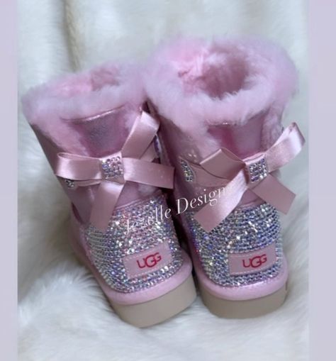 Customized Bling Women's Bailey Bow UGGS II MINI (1 bow) in Metallic Pink. 💎 Each boot heel will be hand "crystallized" with care and precision, one SWAROVSKI crystal at at time, glued with the strongest adhesive available to provide a secure and permanent fit. 💎 The total Crystal count = around 1,500 "Diamonds" on your feet. What a personalized touch.. Popular customizations include: initial(s), nicknames, custom shape design (hearts, flowers, etc).  See image above for an example. ★ NOTE:  A Bow Ugg, Sparkle Boots, Bow Uggs, Cute Uggs, Uggs With Bows, Fluffy Shoes, Ugg Boot, Pink Uggs, Pretty Shoes Sneakers