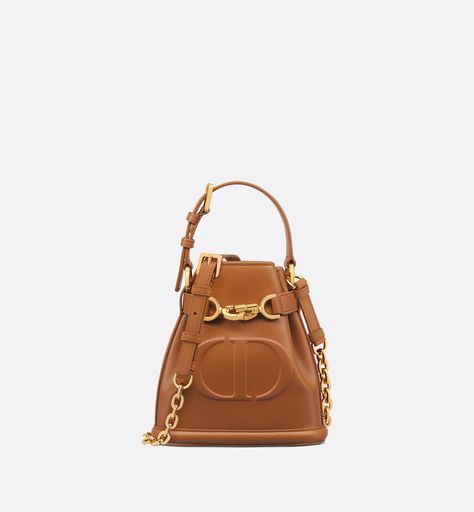 New for Fall 2023, the C'est Dior bag is an elegant and timeless creation. Crafted in golden saddle calfskin, it is distinguished by the embossed CD signature on the front in tribute to the House's savoir-faire. Thanks to its CD Lock closure with a twisting letter D, the bucket bag can keep the essentials secure. A top handle and adjustable, removable chain strap with a leather insert allow the small bag to be comfortably carried by hand. Womens Designer Bags, Christian Dior Couture, Dior Couture, Wallet Pouch, Letter D, Backpack Tote Bag, Fashion Jewelry Earrings, Boutique Online, Fall 2023