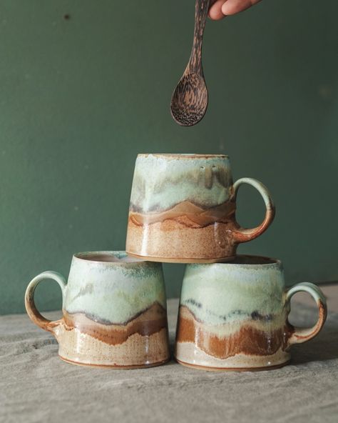 Three medium pottery mugs glazed in browns and greens to represent a coastal scene Handbuild Pottery Mugs, Mug Forms Pottery, Ceramics Mugs Handmade, Hand Painting Pottery, Mug Throwing, Ceramic Pottery Mugs Design, Glazing Mugs Ideas, Potter Glaze Ideas, Cute Mugs Pottery