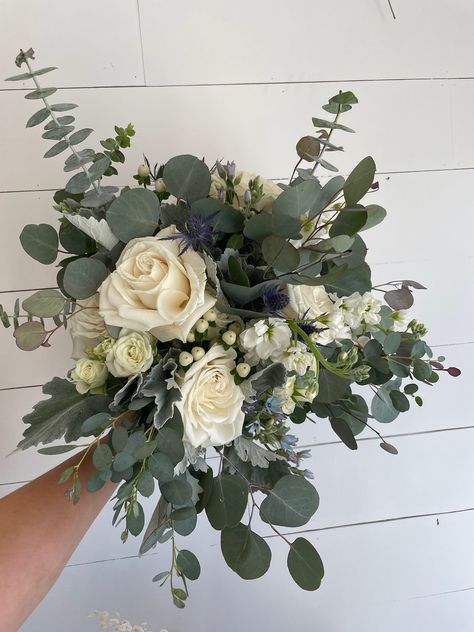 A bridal bouquet featuring white roses, hypericum berry, stock, tweedia, erygnium and eucalyptus greenery Greenery Only Bridal Bouquet, Gardenia And Eucalyptus Bouquet, Bridal Bouquet Eucalyptus White, Eucalyptus In Bouquet, Wedding Bouquets White Roses And Eucalyptus, White Rose And Eucalyptus Floral Arrangements, Eucalyptus Roses Bouquet, Eucalyptus Rose Bouquet, Eucalyptus Summer Wedding