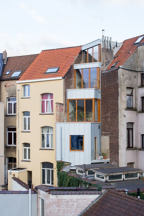 On the west side of the Place Hermann-Dumont, a complex of 3 houses, now protected, reflects an architectural project from the beginning of the 20th century. One of the three houses is located on the fold where the square meets the street. The Brussels typology then adapts to the contingencies of a corner plot. Today, the project is the starting point for a new reflection on living spaces. The living space is intended to have a ‘variable geometry’, allowing flexibility between common and private Neoclassical House, Narrow House Plans, Arch House, Narrow House, Corner House, Brussels Belgium, Minimalist Architecture, Architecture Old, Facade Design