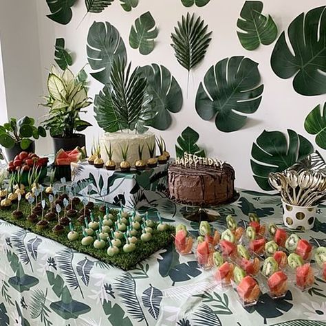 Create a tropical themed party ambiance and set up an enticing dessert station. Dress up the table in a tropical leaf print tablecloth and give your desserts a unique look by presentation them on a grass rug. Choose clear dessert cups, black cake stands, & cake riser to showcase the tempting treats and put gold cutlery in a polka dot cup. Create an authentic tropical feel by using palm leaves as cake topper and decorate the wall with Monstera leaves to add color and texture to your party decor. Tropical Dessert Table, Tropical Birthday Theme, Palm Springs Pool Party, Brazilian Sweets, White Dessert Tables, Tropical Wedding Reception, Event Decor Ideas, Hen Night Ideas, Party Decorations Table